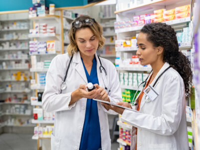 Two female pharmacists looking at a medication.