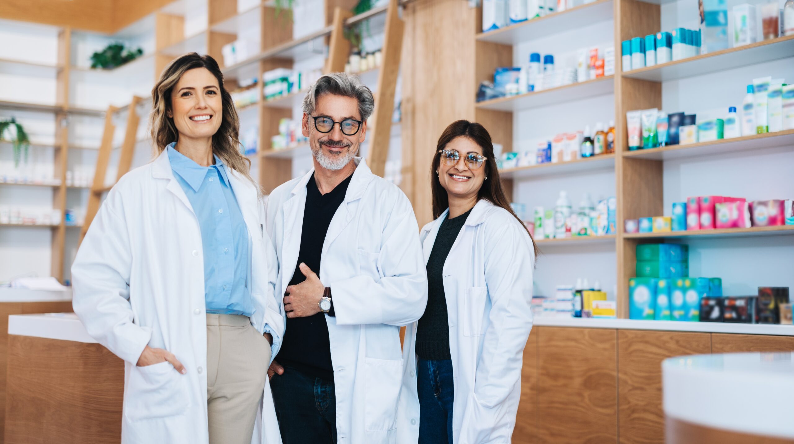 Three pharmacists standing together and looking at the camera.