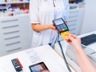 Pharmacist holding card reader for patient