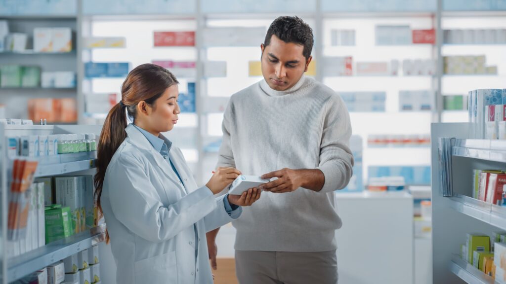 A female pharmacist helping a man select a medication.