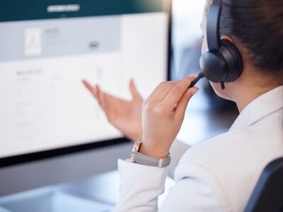 Pharmacist utilizing phone headset while on computer