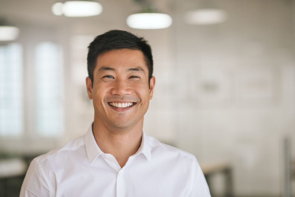 A young man smiling and looking at the camera.