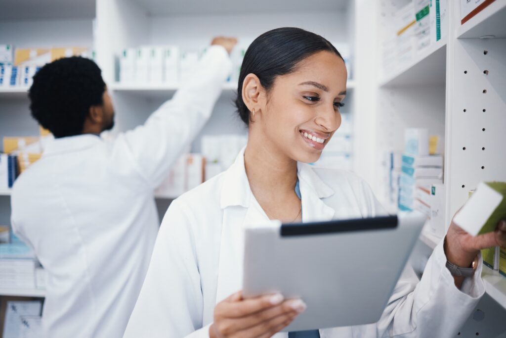 A female pharmacist using a tablet to check meds.