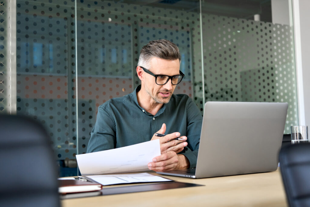 A mature businessman having a virtual meeting on his laptop.