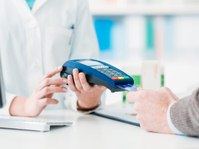 A man using a credit card to pay at a pharmacy.