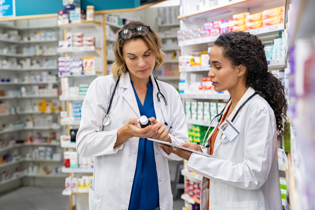 Two female pharmacists looking at a medication.