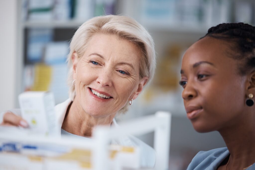 Pharmacist showing woman medication.