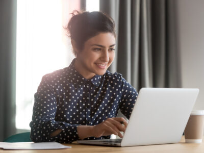 A happy young business woman using computer.